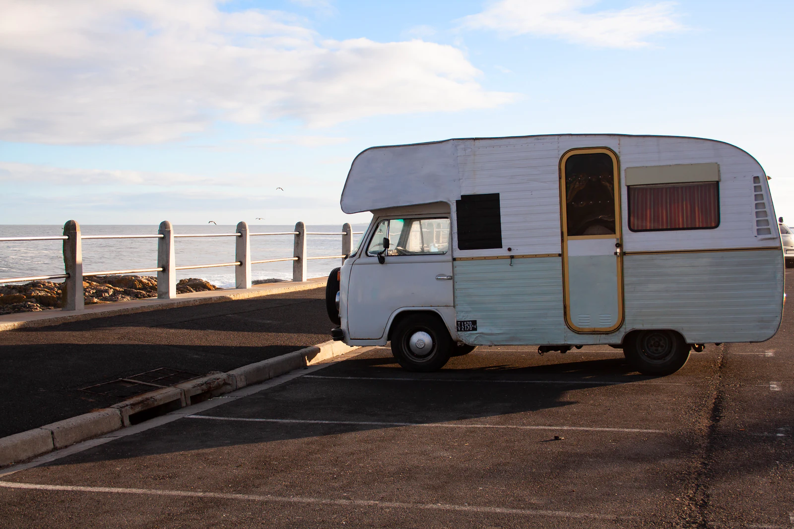 Autocaravana estacionada en un aparcamiento junto al mar