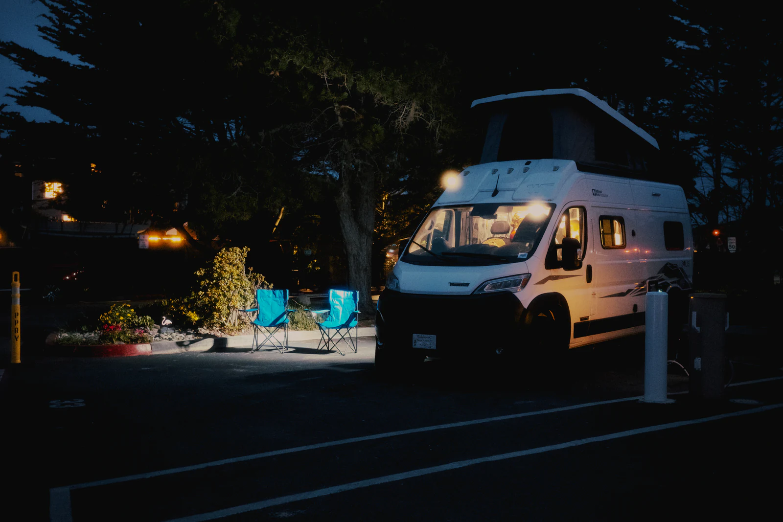 Furgoneta camper aparcada de noche en una parcela de camping